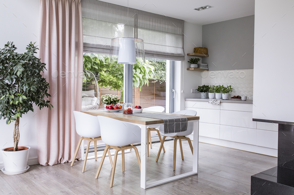 Gray roman shades and a pink curtain on big, glass windows in a Stock Photo by bialasiewicz