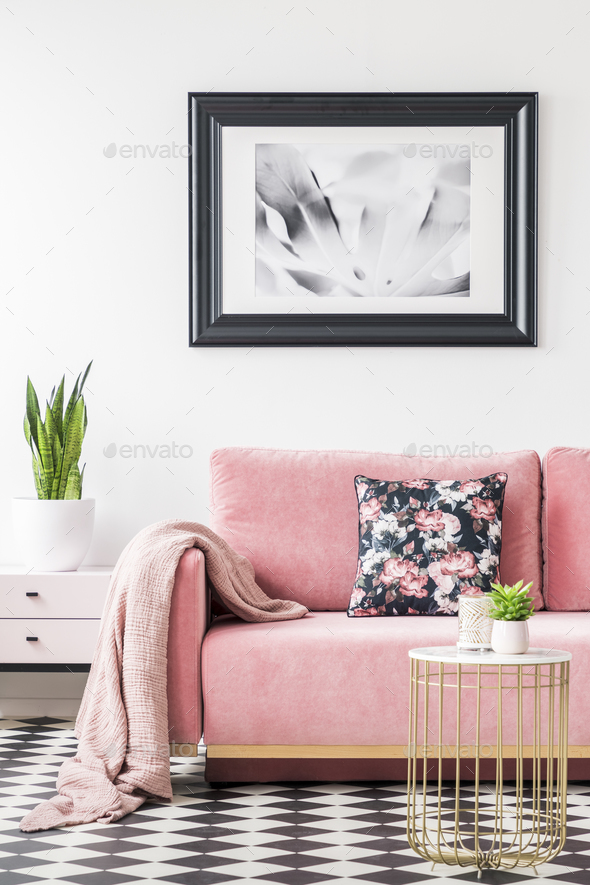 Floral pillows and blanket on pink couch in living room interior Stock Photo by bialasiewicz