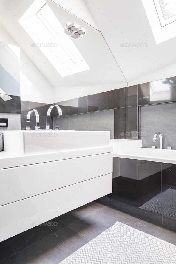 Big mirror by a modern, white washbasin cabinet in a fancy bathr Stock Photo by bialasiewicz