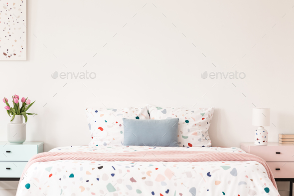 Real photo of a double bed with dotted sheets and pillows on an Stock Photo by bialasiewicz