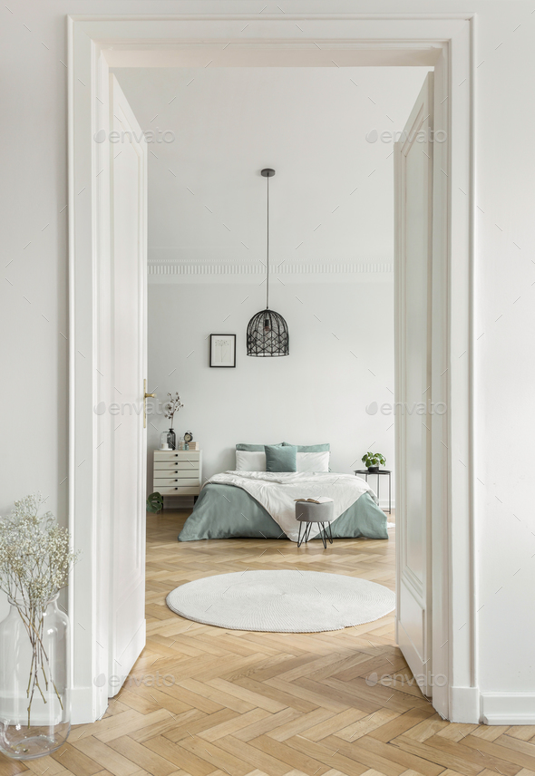 Real photo of open door to bright bedroom interior with king-siz Stock Photo by bialasiewicz
