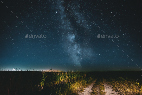 Night Starry Sky With Milky Way Glowing Stars Above Country Road Stock Photo by Grigory_bruev
