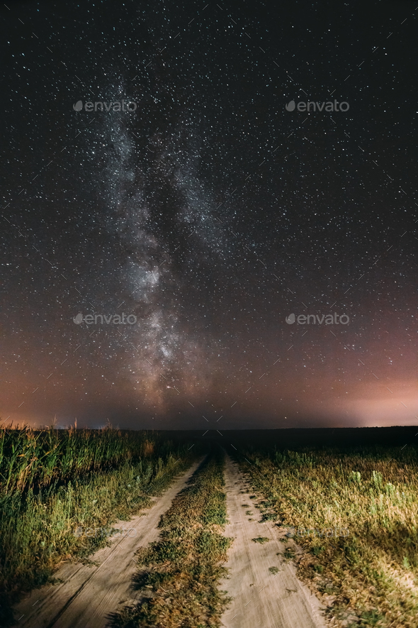 Night Starry Sky With Milky Way Glowing Stars Above Country Road Stock Photo by Grigory_bruev