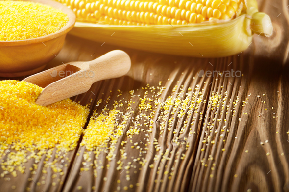 Bowl of corn grits and corncob on kitchen table Stock Photo by e_mikh
