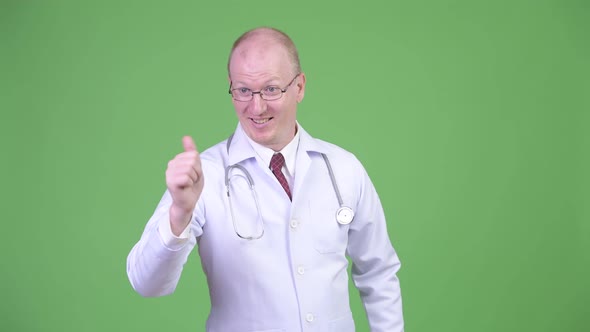 Happy Mature Bald Man Doctor Thinking While Giving Thumbs Up Stock Footage