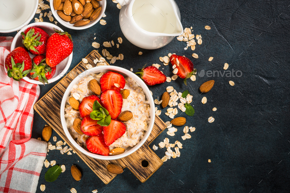 Oatmeal Porridge With Fresh Strawberry And Nuts On Dark Background