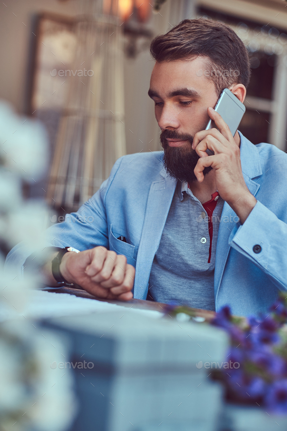 Fashionable Bearded Male With A Stylish Haircut Sitting In A Cafe