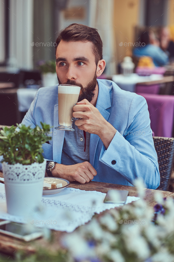 Fashionable Bearded Male With A Stylish Haircut Sitting In A Cafe