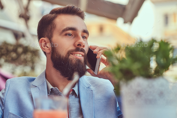 Fashionable Bearded Male With A Stylish Haircut Sitting In A Cafe