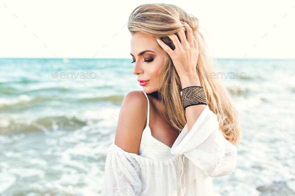 Close Up Portrait Of Blonde Girl With Long Hair Dreaming On Sea