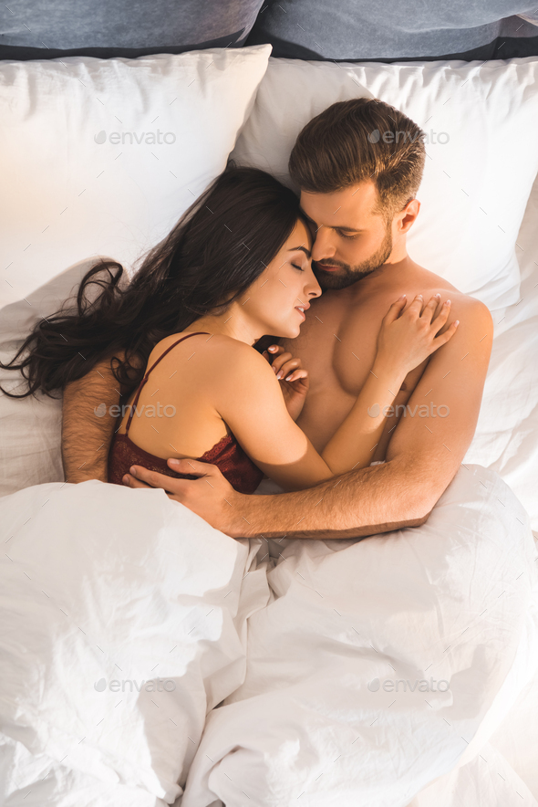 Guy and girl in bed naked cuddling