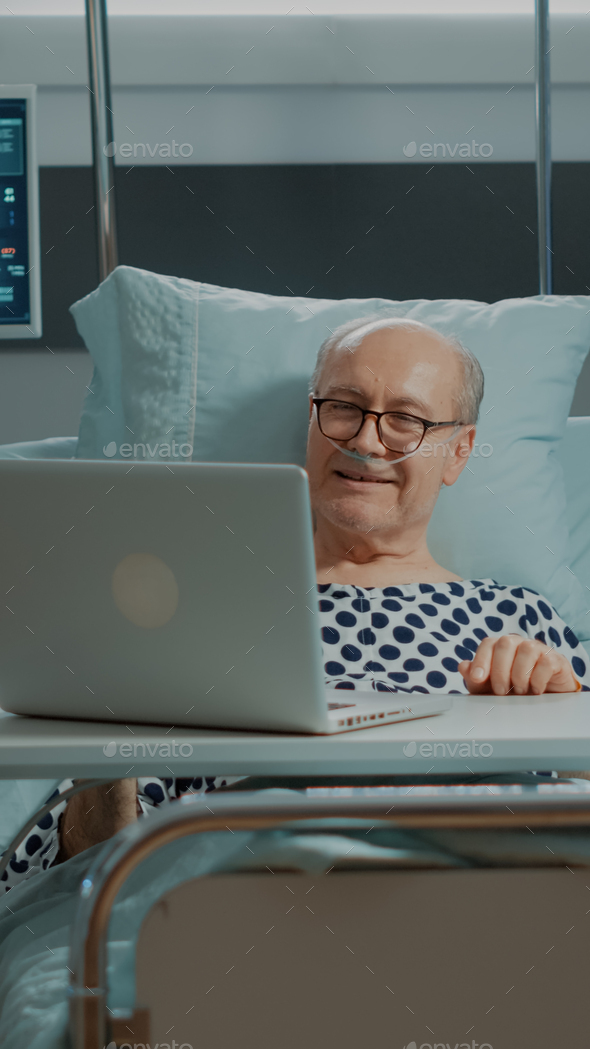 Sick Patient Using Laptop In Hospital Ward Bed At Clinic Stock Photo By