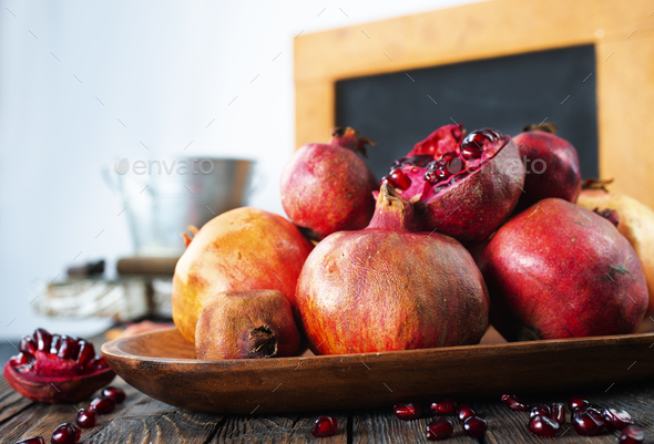 Still Life With Red Granates Pomegranates On Wooden Plate Stock Photo