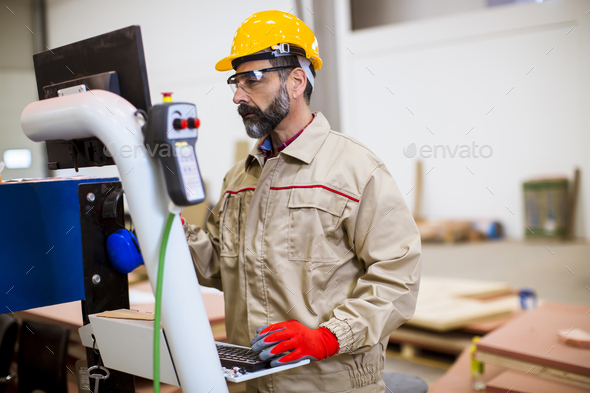 Senior Man Operating Machine Units In Modern Factory Standing By