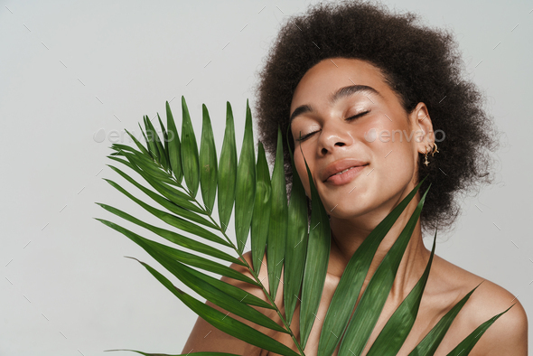 Black Shirtless Woman Smiling While Posing With Green Leaf Stock Photo