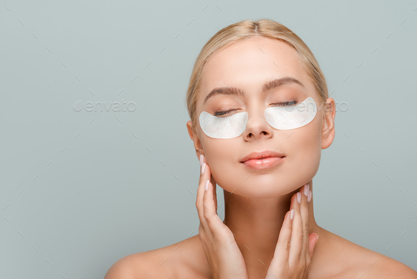 Naked Woman With Eye Patches Touching Face Isolated On Grey Stock Photo