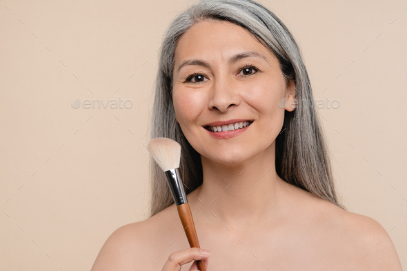 Smiling Mature Middle Aged Shirtless Naked Woman Applying Makeup On Her