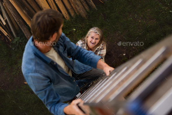 High Angle View Of Mature Man Climbing Up The Ladder Looking At His