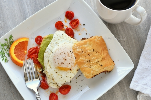 Avocado Toast With Sunny Side Up Egg Made On A Croissant Stock Photo By