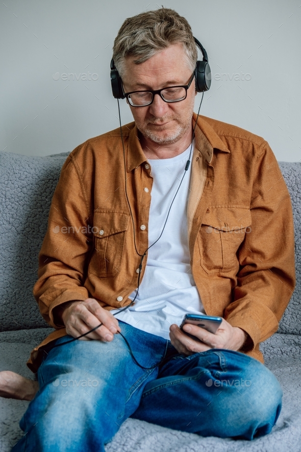 A Candid Portrait Of An Attractive Middle Aged Man Wearing Headphones