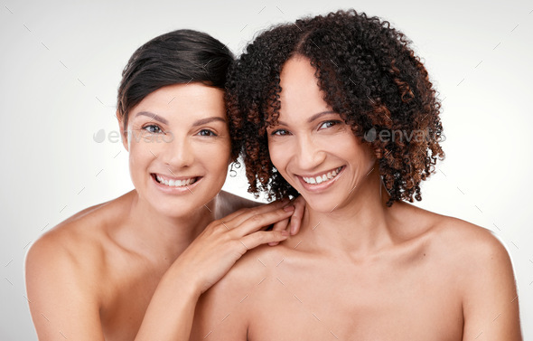 Cropped Portrait Of Two Beautiful Mature Women Posing Against A Grey