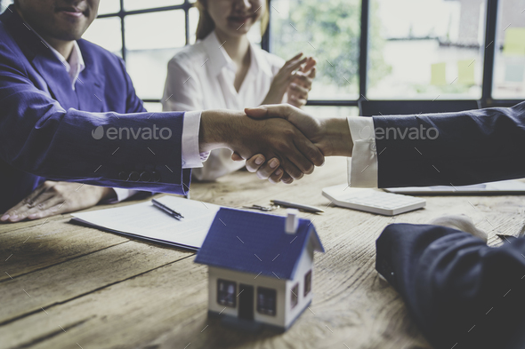 Estate Agent Shaking Hands With Customer After Contract Signature After