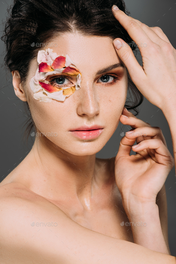 Beautiful Nude Woman With Floral Petals Around Eye Isolated On Grey