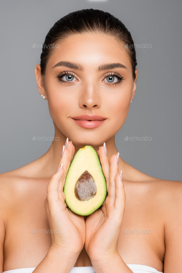 Woman With Naked Shoulders And Avocado Half Isolated On Grey Stock