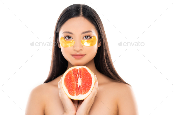 Naked Asian Woman With Golden Eye Patches On Face Holding Half Of Juicy