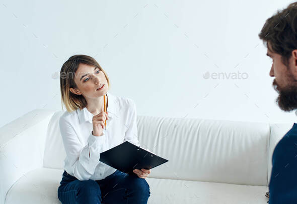 Business Man In A Classic Suit And A Woman On The Couch With Documents