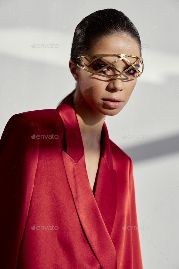 Portrait Of An Attractive Woman With An Accessory On Her Face And A Red