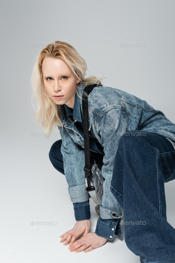 Blonde Albino Model In Stylish Denim Outfit With Belt Bag Posing On Grey Stock Photo By