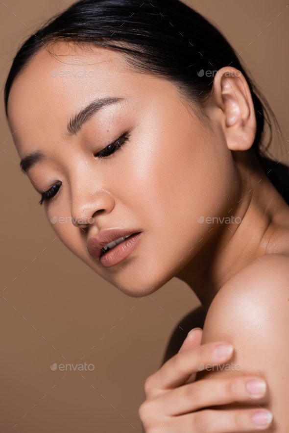 Brunette Asian Woman Touching Naked Shoulder Isolated On Brown Stock