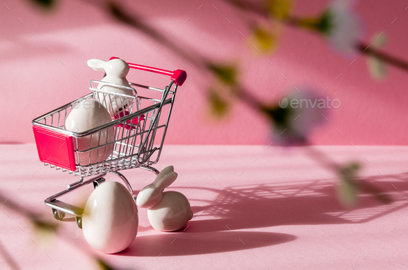 Porcelain Easter Eggs Bunny And Shopping Cart On A Pink Background