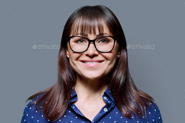 Headshot Portrait Of Smiling Mature Woman On Grey Background Stock