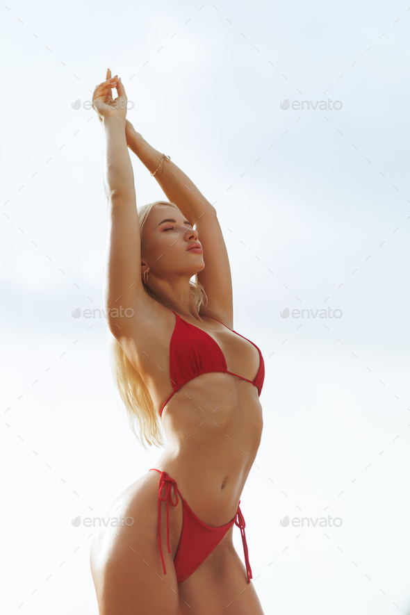 Blonde Fit Woman In Red Bikini Posing On Sunny Beach During Vacation