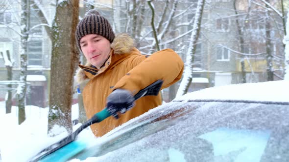 A Man Brushes Snow From A Car After A Snowfall By Simol1407 VideoHive