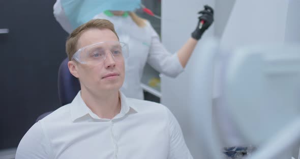 Dentist Puts A Napkin On A Patient Preparation Before Dentistry Stock Footage