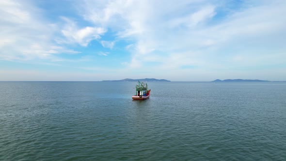A fisherman is sailing in the sea among the islands near the coast. alt