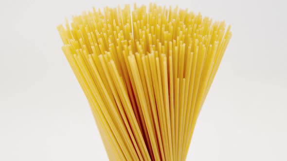 Bunch of raw spaghetti tied up with rope vertically alt