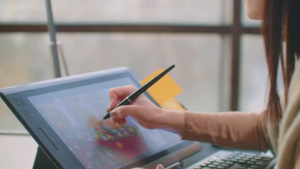 Young Woman Sitting at Her Desk She's Drawing Writing and Using Pen with Digital Tablet Computer alt