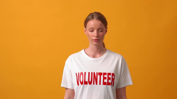 Serious woman volunteer opening eyes at the camera alt