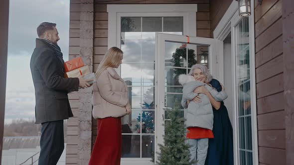 Family with Kids Comes in the House of Grandparents to Celebrate Christmas