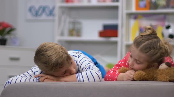 Smiling Children Lying on Sofa and Looking at Camera, Siblings Friendship alt