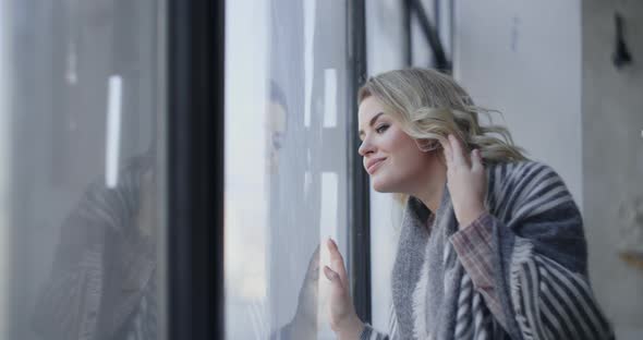 Attractive Young Woman Comes To the Big Window and Looks Through It, Watching Somebody Through the alt