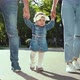  Parents Hold Hands of Toddler Girl Walking in Sunny Park in Summer with Lens Flare Effect - VideoHive Item for Sale