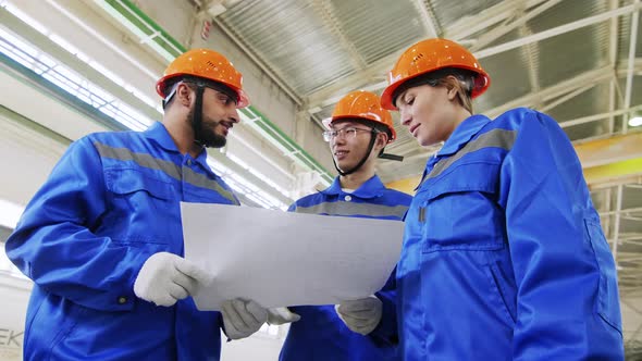 Successful multi ethnic engineers staying at factory