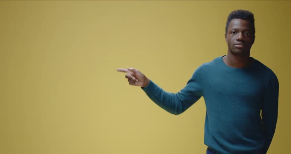 Smiling Young Man Pointing Right alt