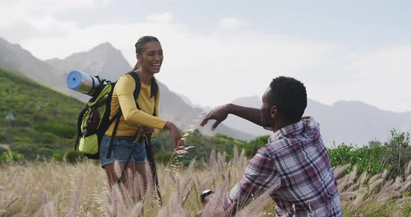 African american couple high fiving each other while trekking in the mountains alt