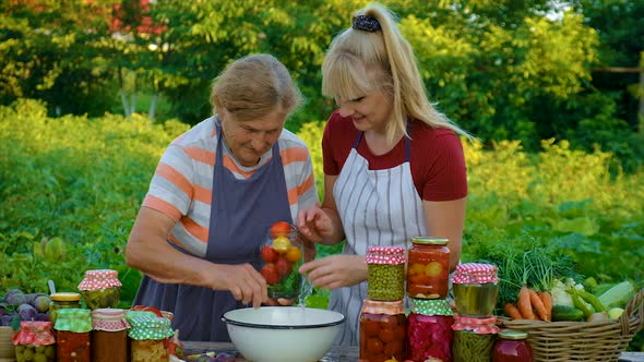 Women with Jar Preserved Vegetables for the Winter Mother and Daughter alt